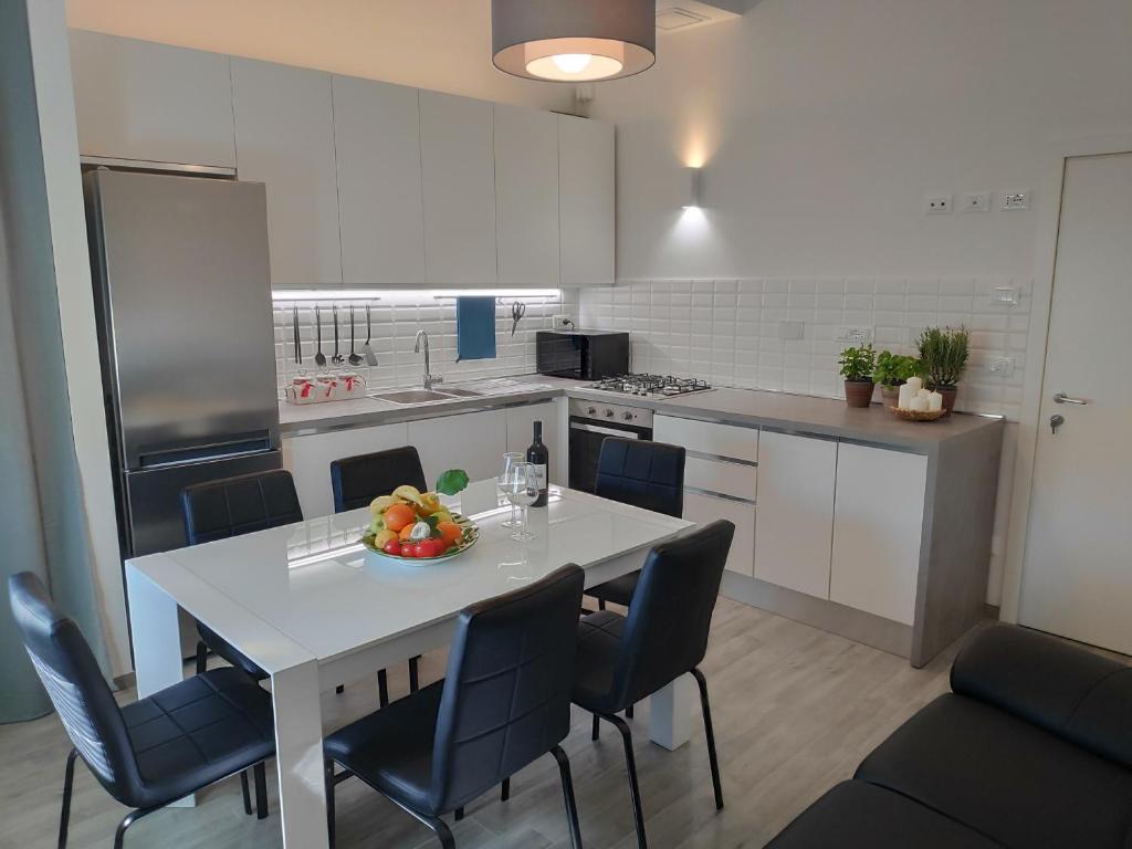 una cucina con un tavolo con una ciotola di frutta sopra di Casadei Guest House Stazione Bologna a Bologna