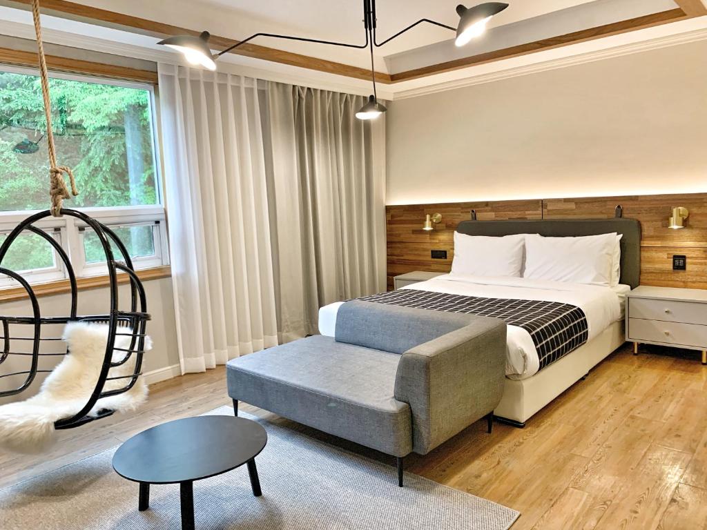 um quarto com uma cama, uma cadeira e uma mesa em Fresh Hill em Cheongdo