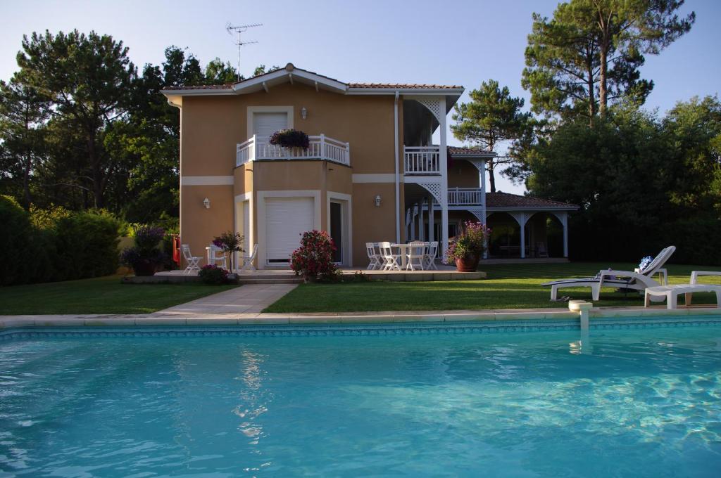una casa con piscina frente a ella en LE CLOS D'IGNAC, en Lège-Cap-Ferret