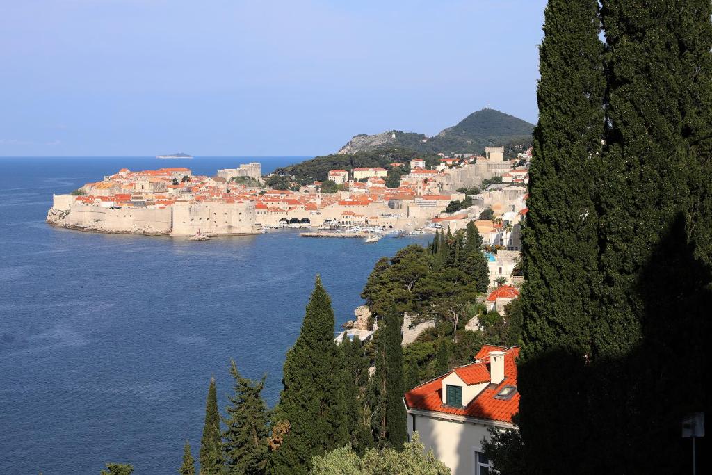 uitzicht op een stad op een heuvel naast het water bij Golden Creek Amazing Sea Views Apartment in Dubrovnik