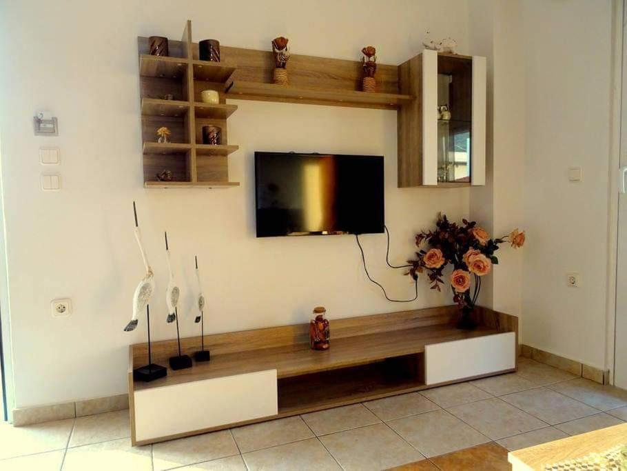 a living room with a flat screen tv on a wall at Cozy apartment in Paradisi in Paradeísion