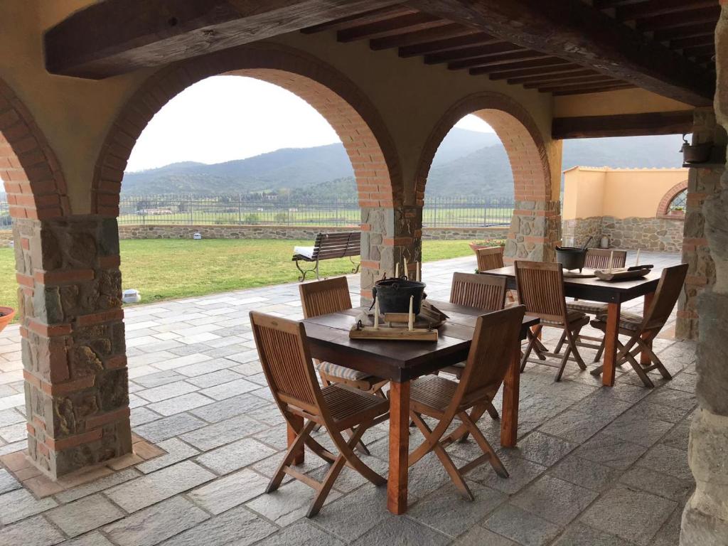 a patio with wooden tables and chairs on a patio at Bellavista Prile in Castiglione della Pescaia