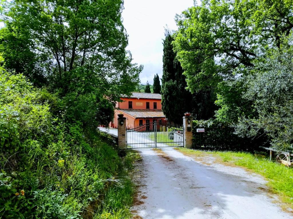 een onverharde weg die leidt naar een huis met een poort bij B&B Cà Giovanni Country Resort in Urbino