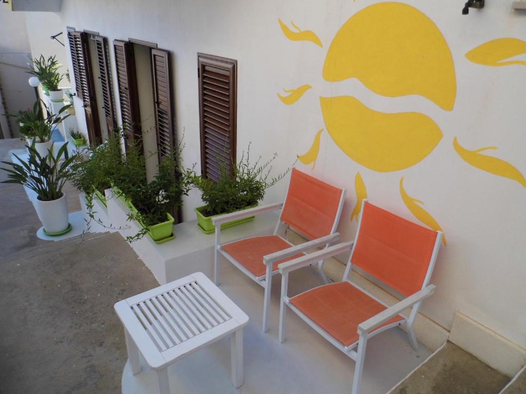 レヴァンツォにあるLa Plaza Residence Levanzoの壁前の椅子2脚とベンチ