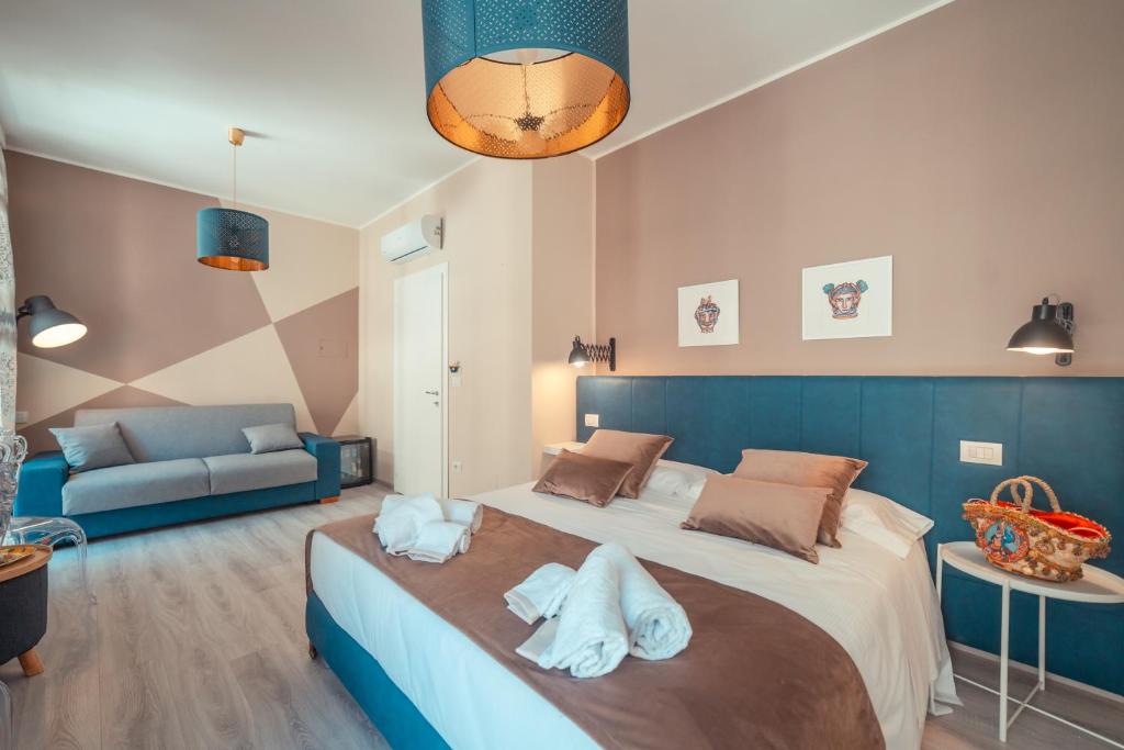 1 dormitorio con 1 cama grande y toallas. en A'Coffa - Rooms&Breakfast, en Taormina