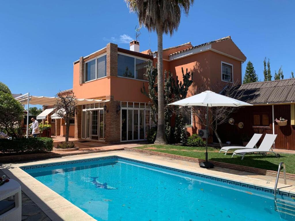 uma casa com piscina em frente a uma casa em Chalet con piscina a 50 m de la playa . em Marbella