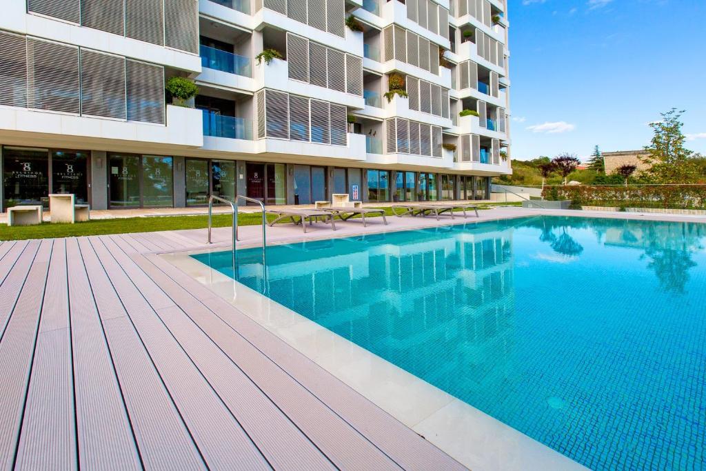 a swimming pool in front of a building at Bel Etage Amora Luxury Seaview Apartment with pool in Split