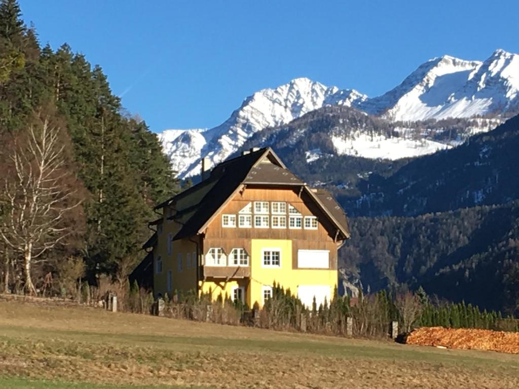 a house in a field with mountains in the background at Villa Fortuna in Oberdrauburg