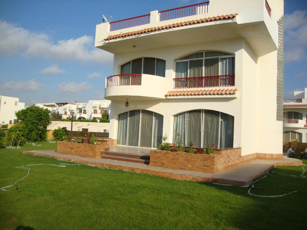 a white house with a lawn in front of it at Luxury Villa Panorama Beach in El Alamein