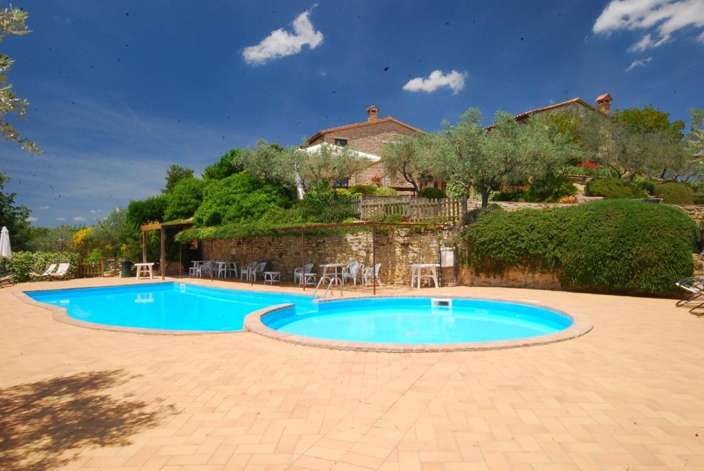 una piscina en un patio con una casa al fondo en Agriturismo La Casella, en San Terenziano