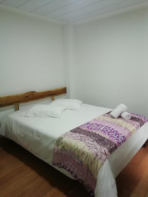 a bed with a blanket on top of it at Elizabetha Hostal in Salento