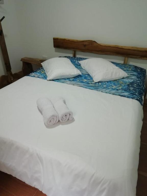 a white bed with two towels on top of it at Elizabetha Hostal in Salento