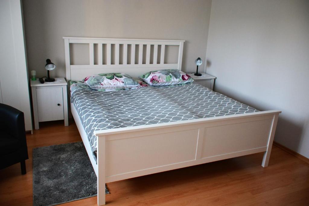 uma cama branca com duas almofadas num quarto em Apartment April em Bled