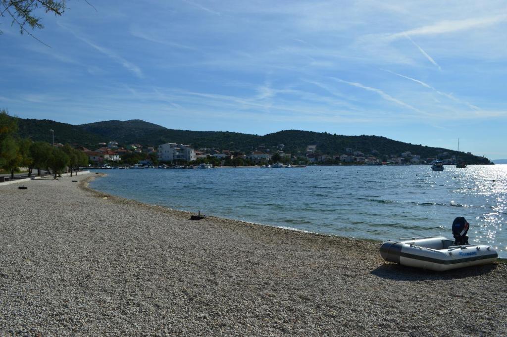 un bateau assis sur une plage au bord de l'eau dans l'établissement Apartmani Marino, à Vinišće