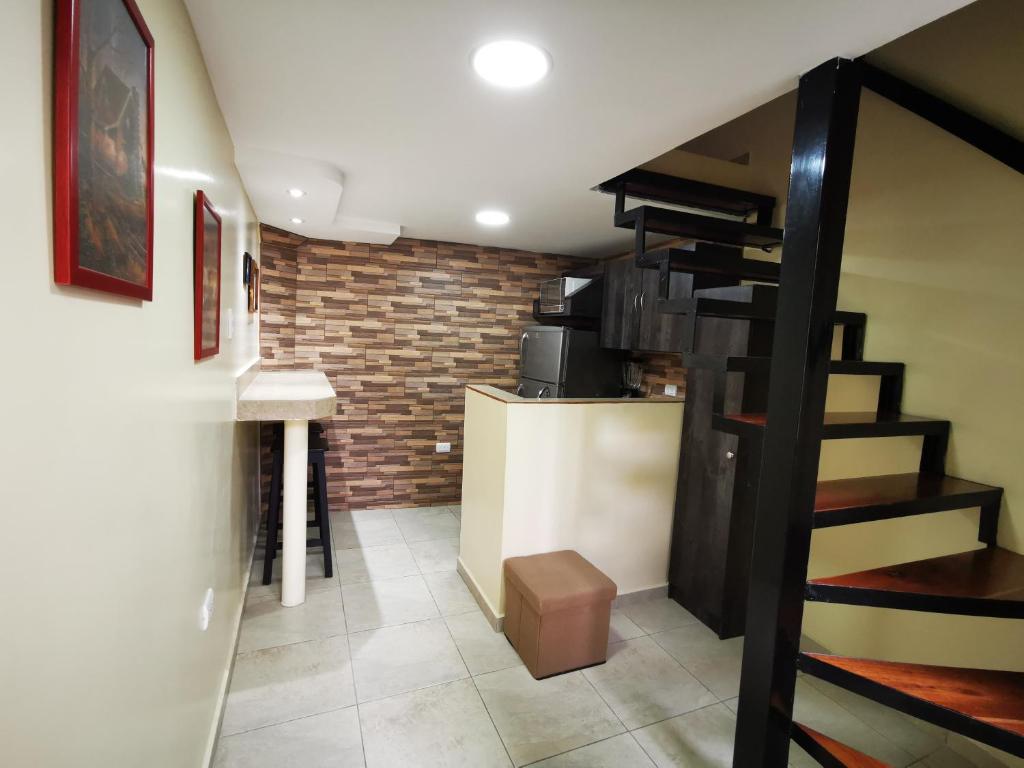 Habitación con escalera y pared de ladrillo. en Apartamento suite para parejas o ejecutivos, en Manta