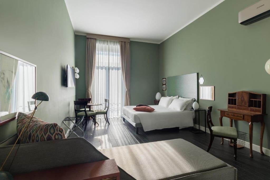 una camera d'albergo con letto e soggiorno di Rinuccini Relais a Napoli
