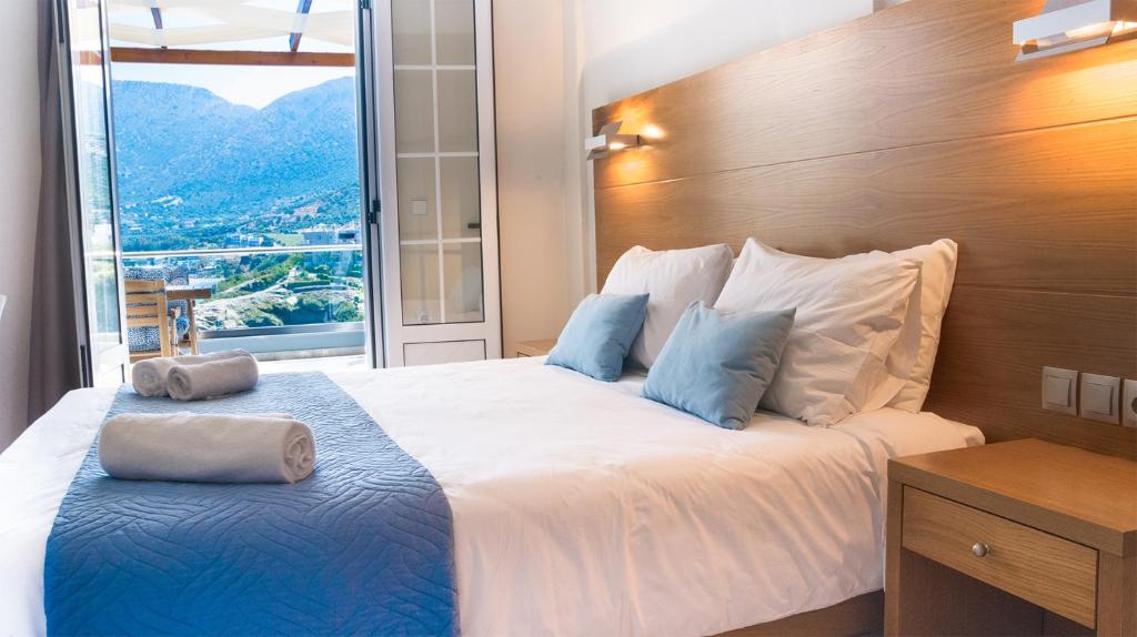 a bedroom with a large bed with a large window at Villa Vasilis in Balíon