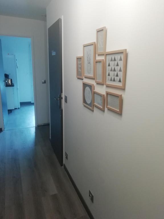 un couloir orné d'un mur blanc avec des photos. dans l'établissement Disneyland/Paris 1 a10 personnes climatisee, à Pontault-Combault