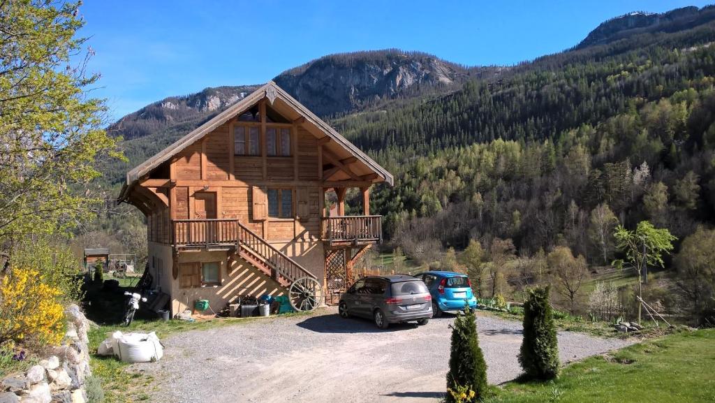 une cabane en rondins avec une voiture garée devant elle dans l'établissement Chalet Gyronde, à Vallouise