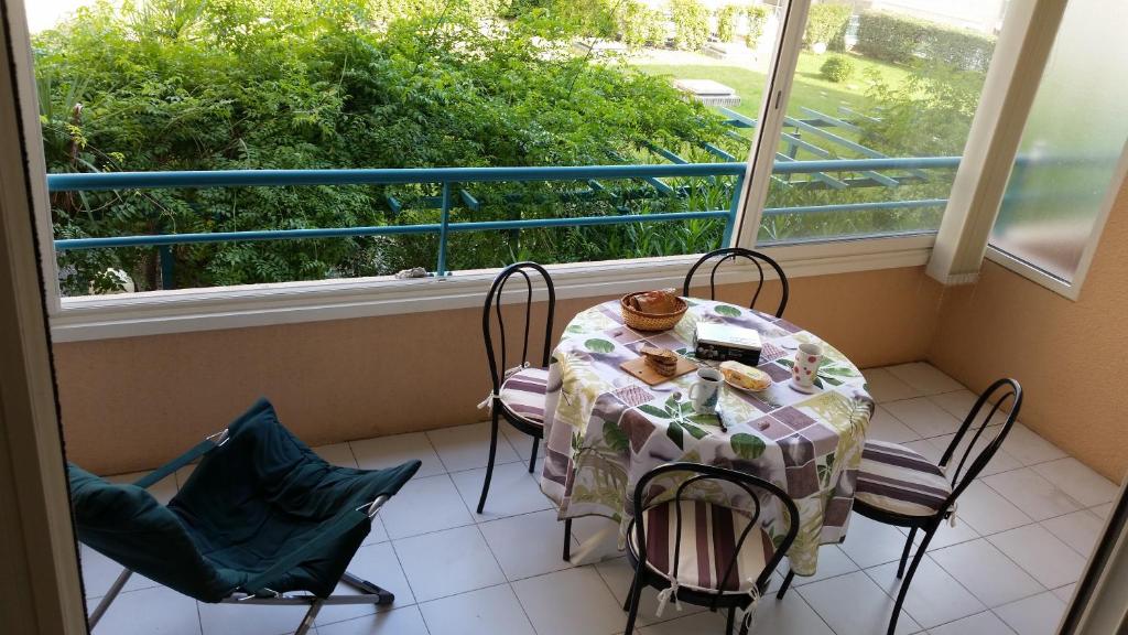 a balcony with a table and chairs and a window at Plage et jardin en centre ville in Saint-Raphaël