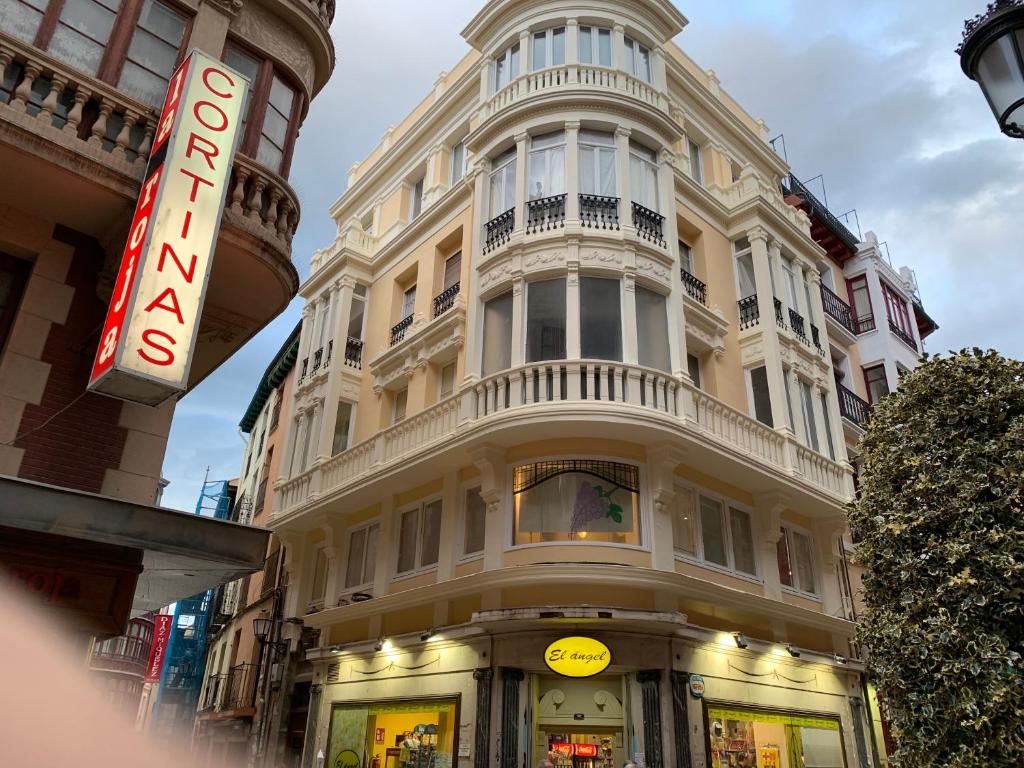 un edificio blanco alto con un cartel delante en Calle Portales Casco Antiguo, en Logroño