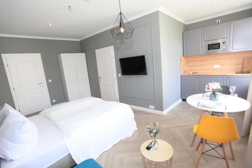 ein Schlafzimmer mit einem Bett und einem Tisch sowie eine Küche in der Unterkunft Zollikof Aparts - Sauna & Studioapartments in Leipzig