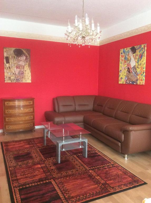 a living room with a brown couch and red walls at Fewo Dresden Zentrum Nähe Hauptbahnhof in Dresden