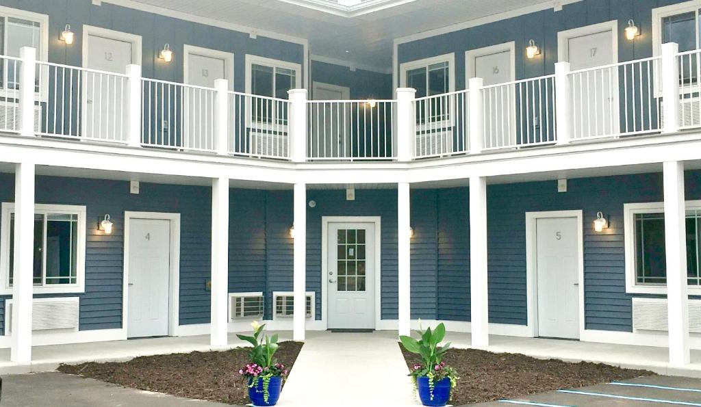 a blue building with white columns and balconies and plants at Empire Lakeshore Inn in Empire