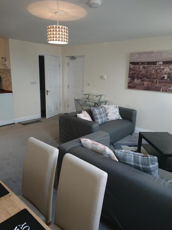 a living room with two couches and a table at Wood Yard Cottages in Long Sutton