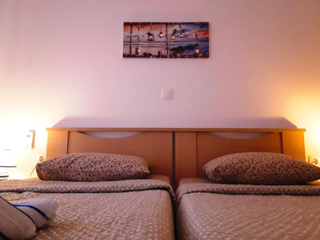 1 dormitorio con 2 camas y mesa en la pared en LARINΑKI'S STUDIO No1, en Amorgós