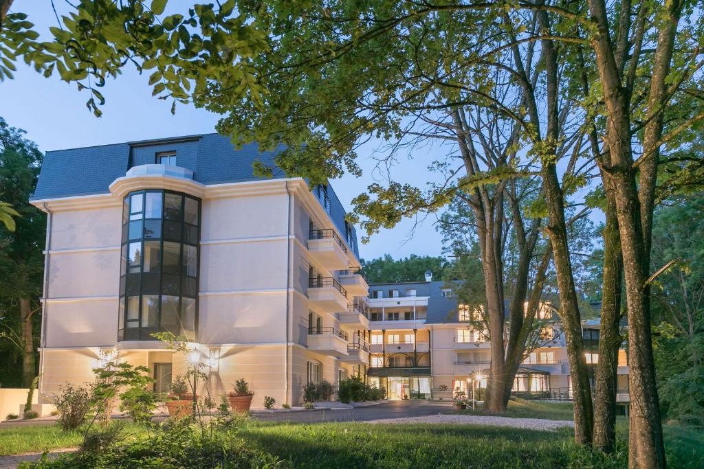 - une vue sur l'extérieur d'un bâtiment avec des arbres dans l'établissement MÉDICIS HOME DIJON LES PETITES ROCHES, à Dijon