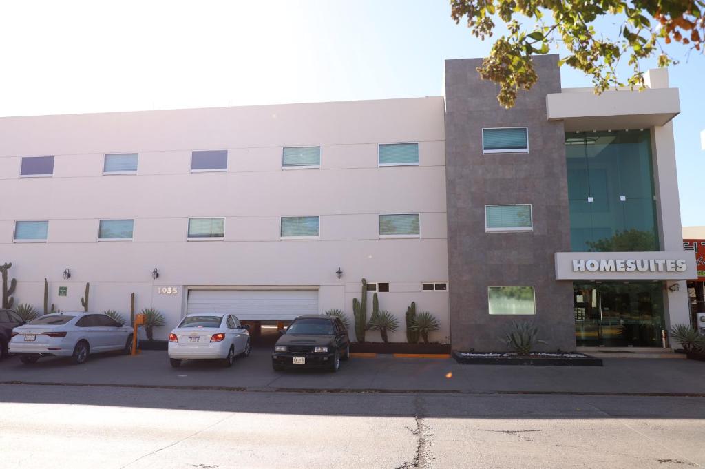 un bâtiment avec des voitures garées devant lui dans l'établissement Homesuites Rotarismo, à Culiacán