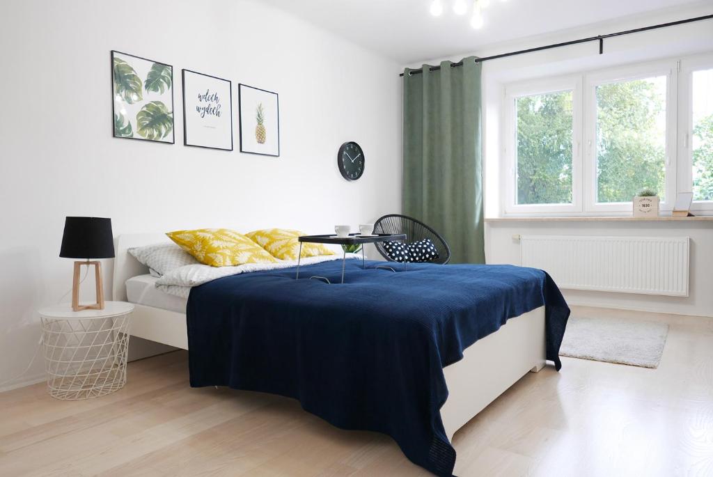um quarto com uma cama com um cobertor azul em Apartament ProLublin em Lublin