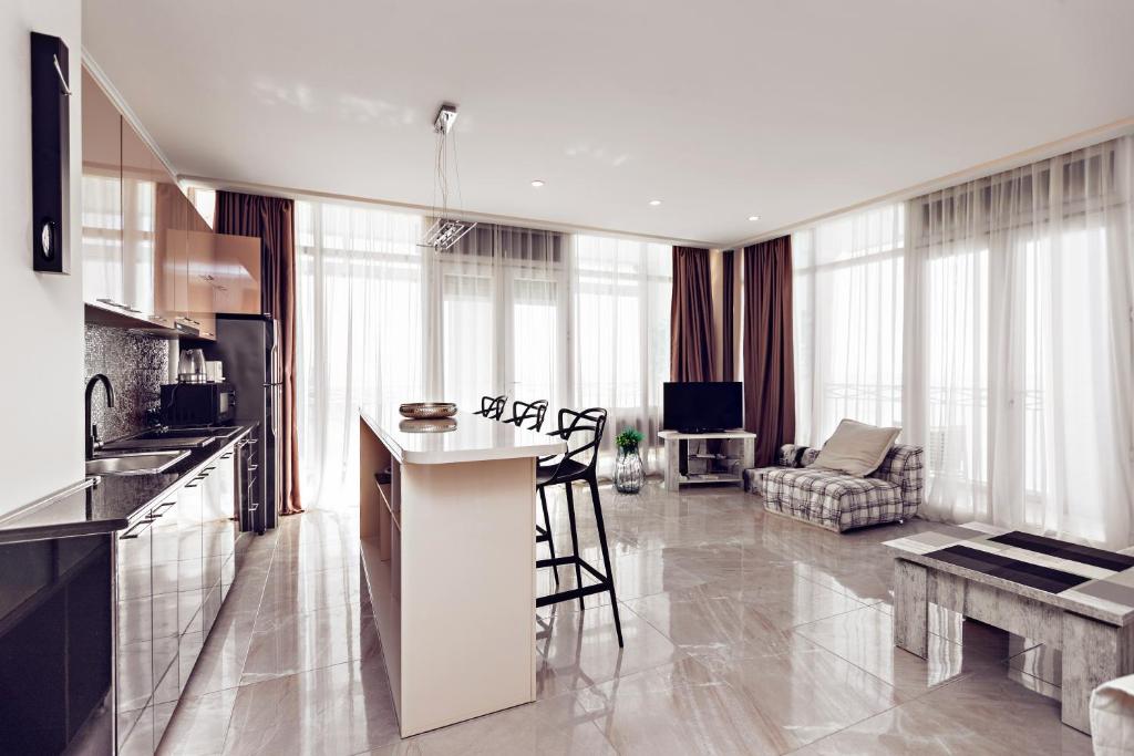 uma cozinha e sala de estar com uma mesa e um sofá em Apartment Magnolia Rustaveli 62 em Batumi