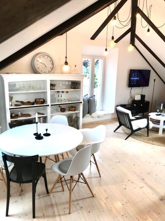 a dining room with a white table and chairs and a piano at Familia in Selca