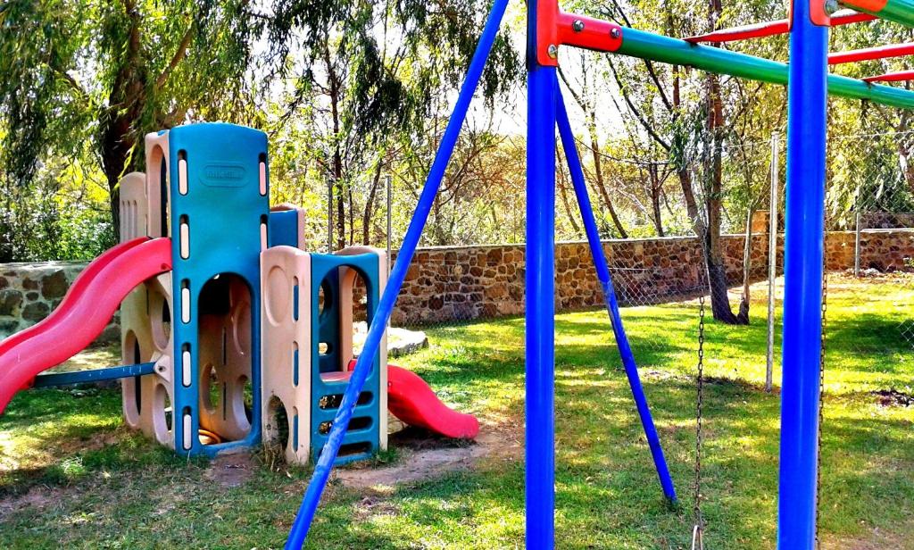 un parque infantil con columpios coloridos en un parque en Entrerrobles, en Valdeavellano de Tera