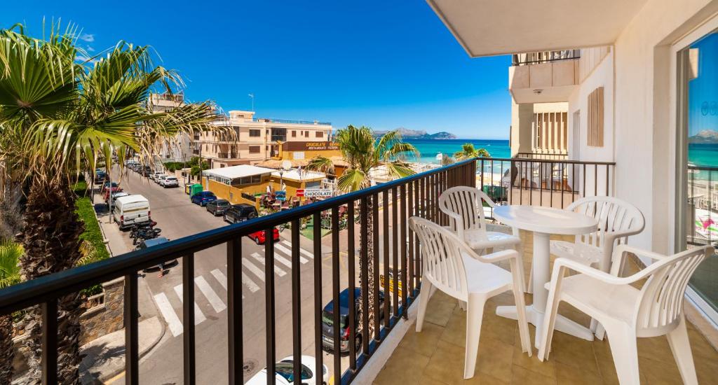 balcón con mesa, sillas y vistas al océano en Apartamentos Charlys Can Picafort, en Can Picafort