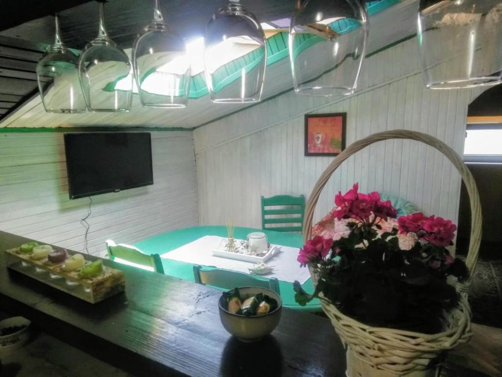 Potkrovlje في فرساك: غرفة معيشة مع طاولة وتلفزيون وزهور