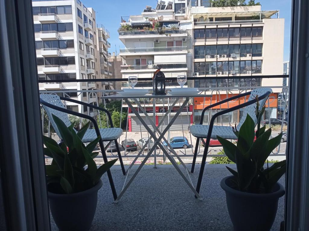 une table et des chaises sur un balcon avec vue sur un navire dans l'établissement Afrodite's apartment (close to Athens city center), à Athènes