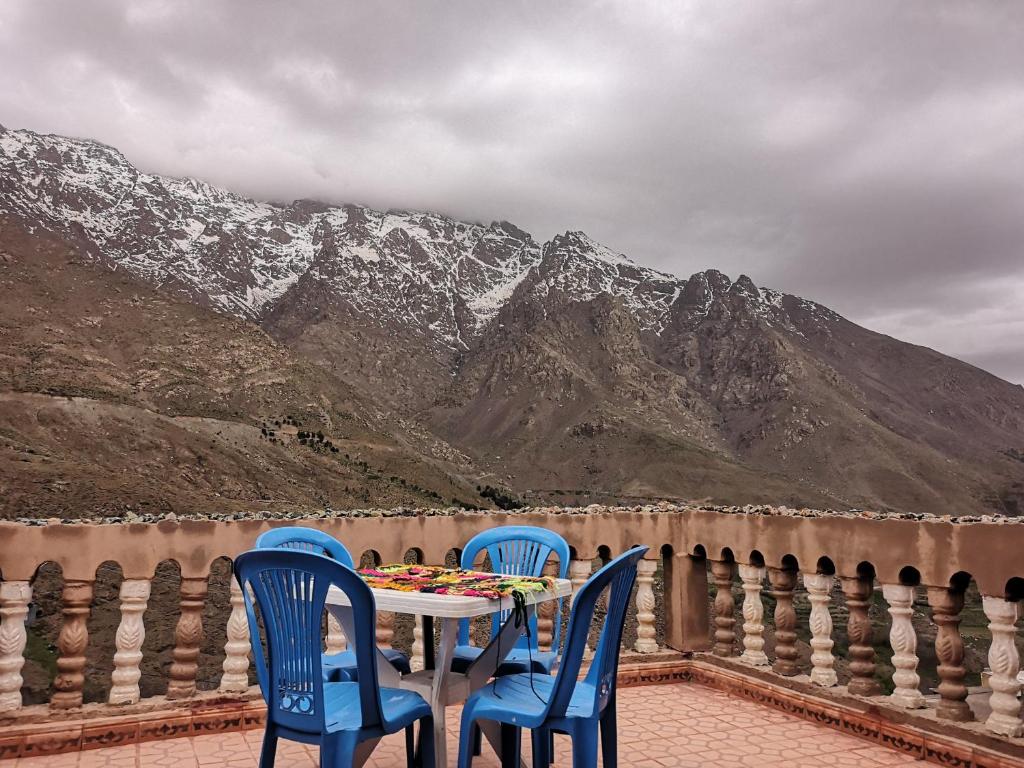2 sillas y una mesa en un balcón con montañas en Gite Angour Tacheddirt, en Tacheddirt