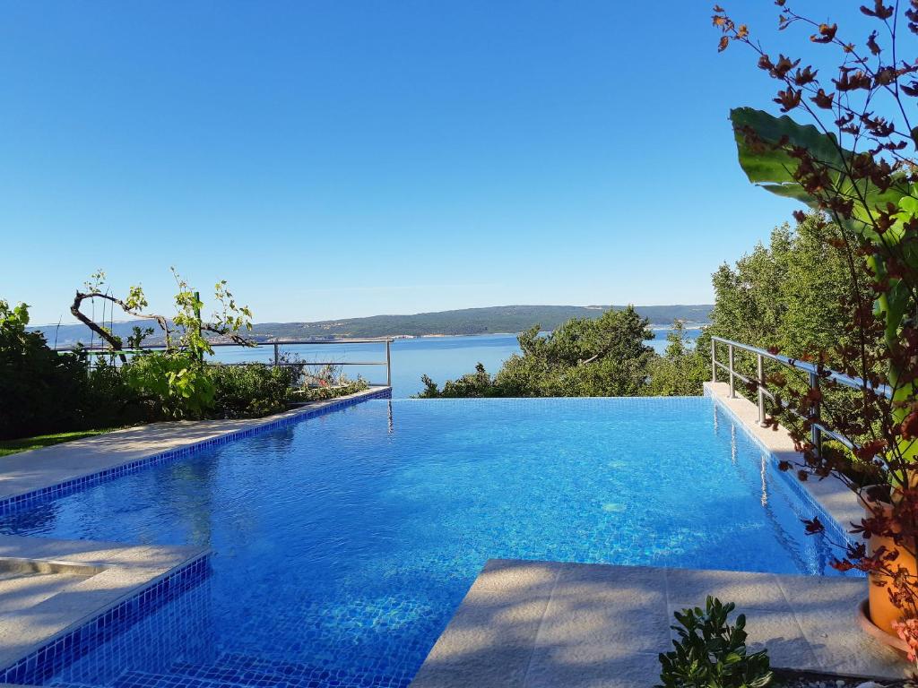 a swimming pool with a view of a body of water at Apartment Milka in Dramalj