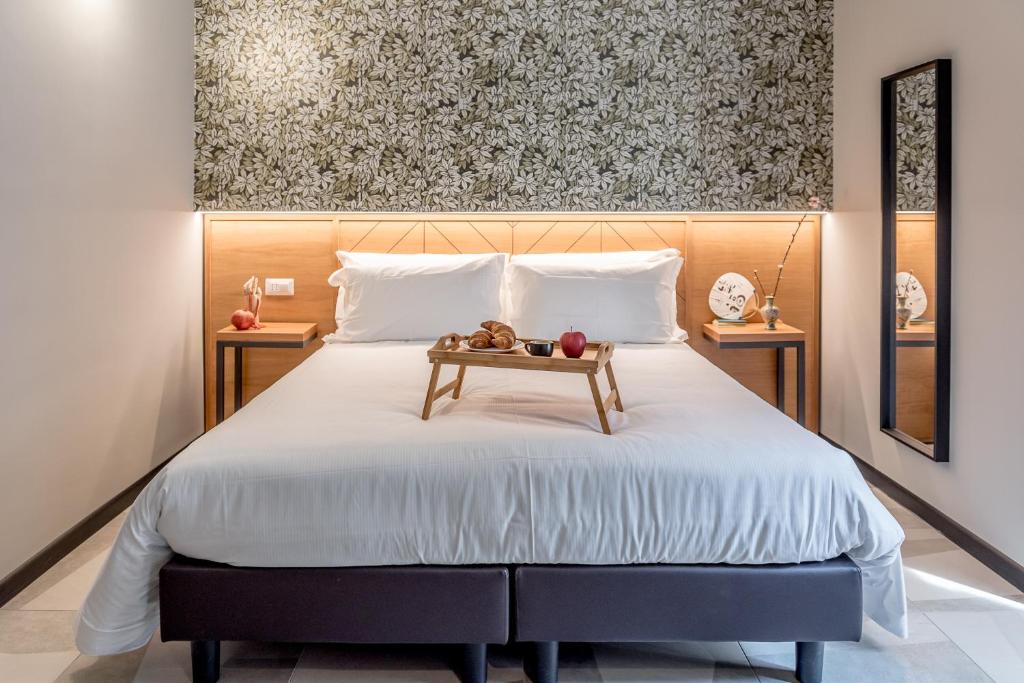 a bedroom with a large bed with a wooden headboard at APARTHOTEL CASA MIA in Milan
