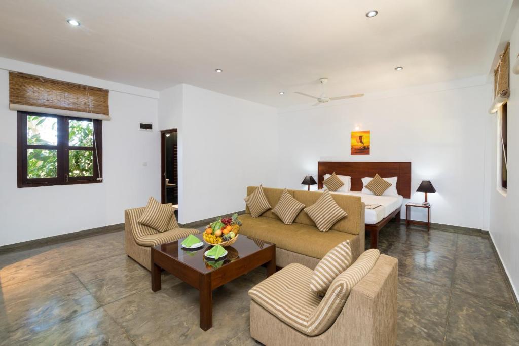 a living room with a couch and a bed at Camellia Resort and Spa in Sigiriya