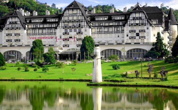 um grande edifício com um lago em frente em Palácio Quitandinha Espetacular Apartamento com Vista para o Lago em Petrópolis