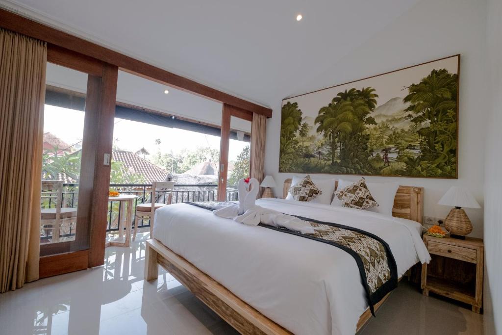1 Schlafzimmer mit 2 Betten und einem großen Fenster in der Unterkunft Nikuna homestay in Ubud