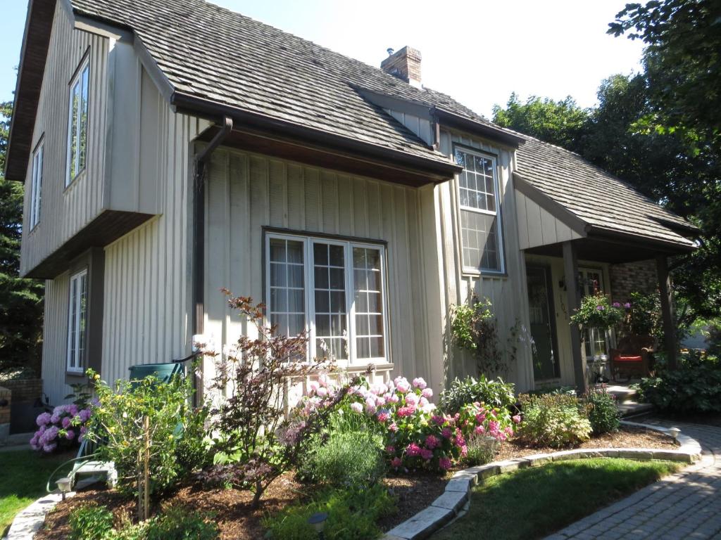 una pequeña casa con flores en el patio delantero en Cedar Gables Bed & Breakfast, en Niagara on the Lake