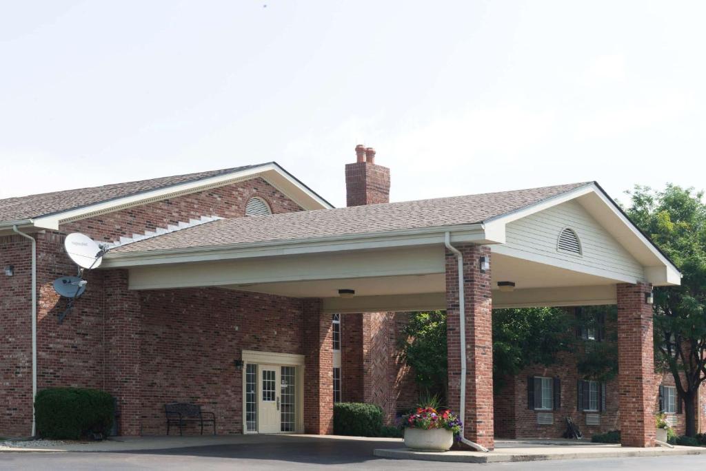 a brick house with a large covered porch at Super 8 by Wyndham Greenfield in Greenfield