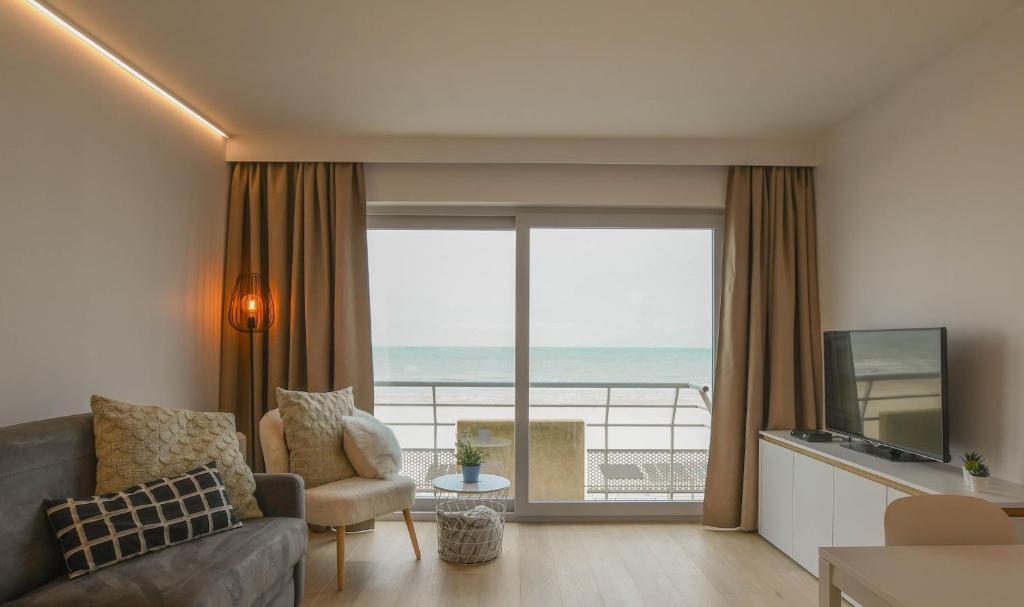 a living room with a view of the ocean at Studio zwembad met frontaal zeezicht in Ostend