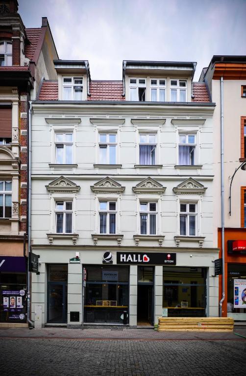 a large white building with ahalla sign on it at Aparthotel CENTRUM Gliwicka 18 in Bytom