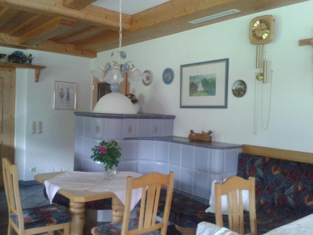 una sala da pranzo con tavolo e vaso di fiori di Landhaus Tuxerschafer a Tux